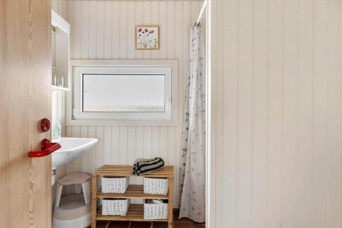a bathroom with a sink and a mirror and a window at TV1694-Bindslev-Musvagevej-8 in Tversted