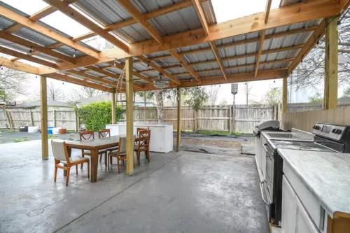 un patio con cocina y una mesa con sillas en Cypress Ct Estate, en Siloam Springs