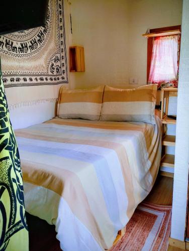 a bedroom with a bed with a white blanket at Casa Nido Tiny House in El Chalten