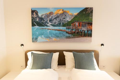 ブレッサノーネにあるecHo Apartments & SPAのベッドと壁に絵が飾られた寝室