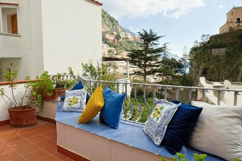 Un banco en un balcón con almohadas encima. en Casa Claudia - Positano Center 5 minutes to beach, en Positano