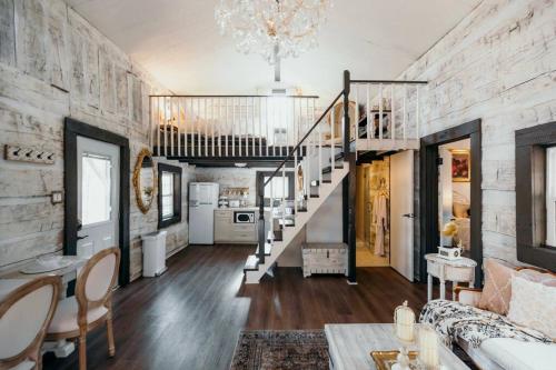 ein Wohnzimmer mit einer Treppe und ein Zimmer mit einem Sofa in der Unterkunft Victorian French Cottage - Hot Tub in Hocking Hills in South Bloomingville