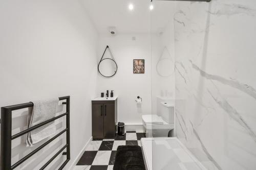 a bathroom with a black and white checkered floor at Elevated Escape - Hot tub, sauna, rooftop terrace in Seabrook