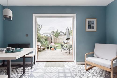 ein Wohnzimmer mit einer Tür, die zu einer Terrasse führt in der Unterkunft Meadow Cottage in Trumpington