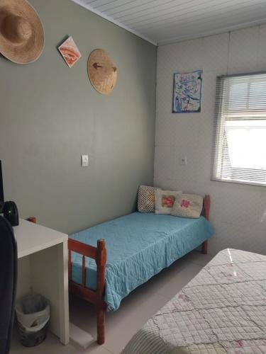 a small bedroom with a bed with a blue blanket at summer house 2026 in Tramandaí