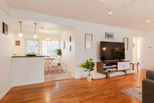 a living room with a television and a table at Spacious Retreat 3 Miles to Airport 12 to Seattle in Burien