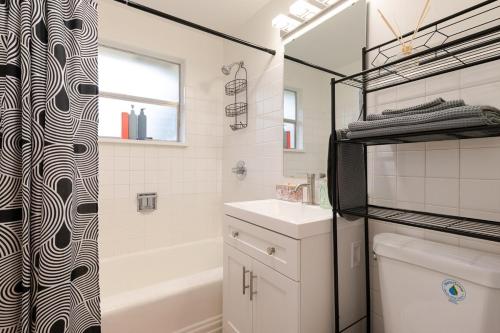 a bathroom with a sink and a shower curtain at Spacious Retreat 3 Miles to Airport 12 to Seattle in Burien