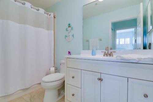 a white bathroom with a toilet and a sink at Waterfront Punta Gorda Condo with Pool Access! in Burnt Store Marina