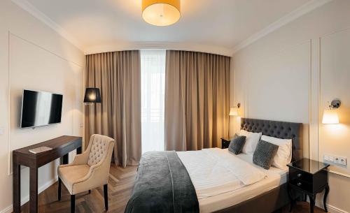 a hotel room with a bed and a desk at Lumina OVO in Wrocław