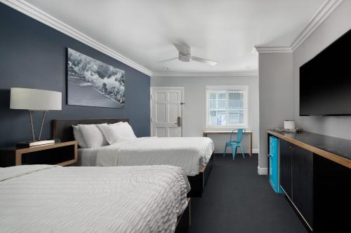 een hotelkamer met twee bedden en een flatscreen-tv bij Beach Haven in San Diego