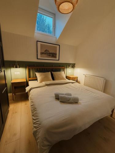 a bedroom with a large bed with two towels on it at Apartamenty Guzik 32 in Krosno