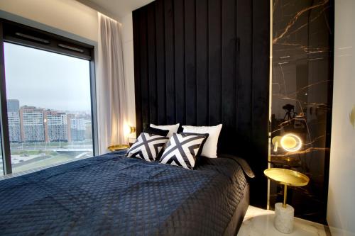 um quarto com uma cama e uma janela grande em Apartament Glamour Olszynki Park em Rzeszów
