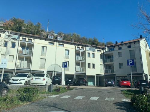 ein Parkplatz mit vor einem Gebäude geparkten Autos in der Unterkunft Appartamento 21 - Smart Apartment nel centro di Segusino, vicino le colline del Prosecco in Sequsino