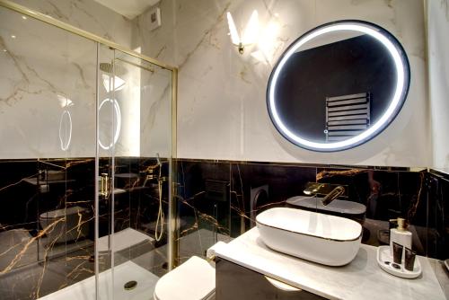 um banheiro com uma pia e um espelho em Apartament Glamour Olszynki Park em Rzeszów