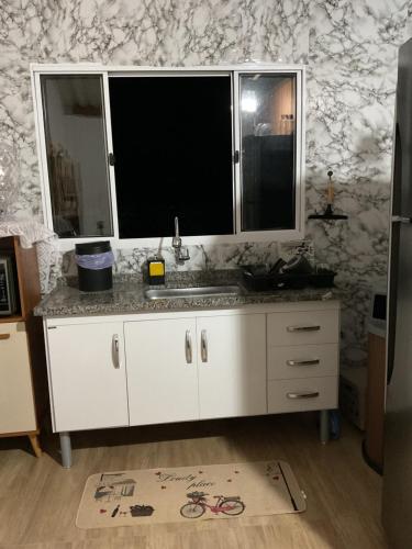 - une cuisine avec un évier et un miroir dans l'établissement Rancho Girassol Casa de Campo em Extrema MG, à Extrema