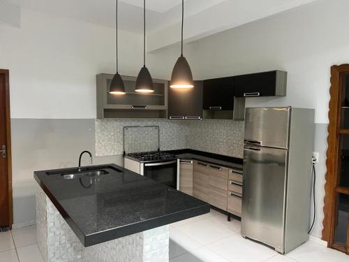 アキダウアナにあるRancho Radicalのキッチン(ステンレス製の冷蔵庫、黒いカウンタートップ付)