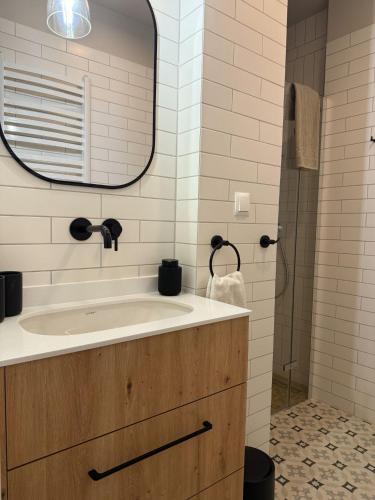 a bathroom with a sink and a mirror at Apartamenty Guzik 32 in Krosno