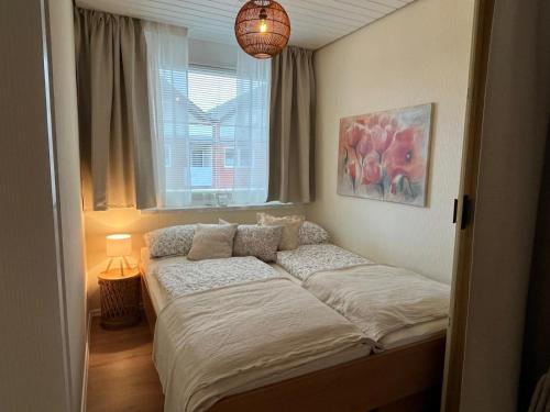 a bed in a bedroom with a window at Ferienwohnung Reede 19 in Butjadingen