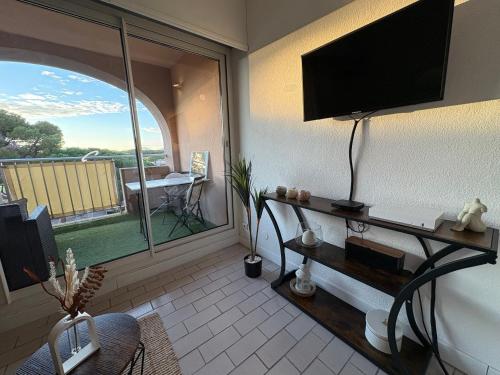 a living room with a flat screen tv on a wall at Studio ensoleillé près du port et des plages in Hyères