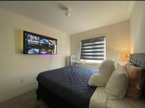 a bedroom with a bed and a tv on the wall at Budget Friendly Home in Oshawa