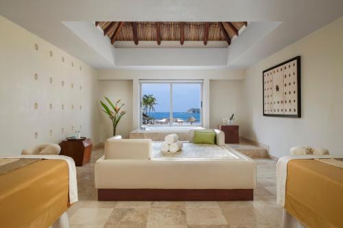 a living room with two beds and a couch at Sunscape Dorado Pacifico Ixtapa Resort & Spa- All Inclusive in Ixtapa
