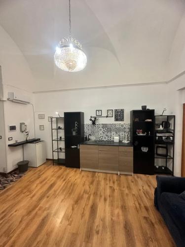 a living room with a hard wood floor and a chandelier at Spàzio apartments Alcalà in Catania