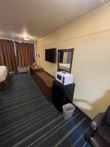 a hotel room with a bed and a television at Rusina Inn in Colorado Springs