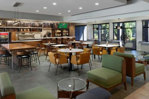 a restaurant with tables and chairs and a bar at Courtyard by Marriott Perimeter Center in Atlanta
