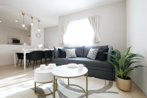 a living room with a blue couch and a table at Skytree Neighbors close to Asakusa & Tokyo Skytree in Tokyo