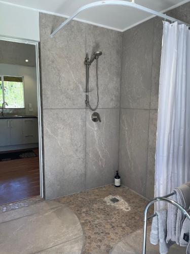 a bathroom with a shower with a shower curtain at Mercury Orchard in Whenuakite