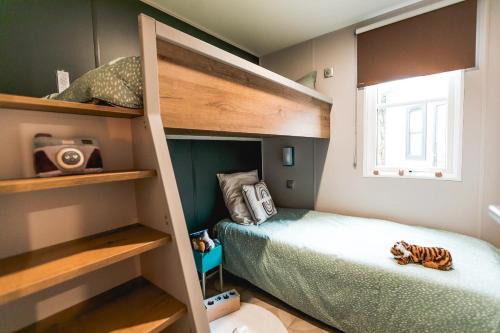 a small bedroom with bunk beds and a bed at Camping Papillon Kinrooi - 78 in Kinrooi