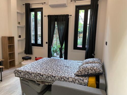 a bedroom with a bed and two windows at Chez Marlène bis, Vieil Antibes, Port Vauban in Antibes