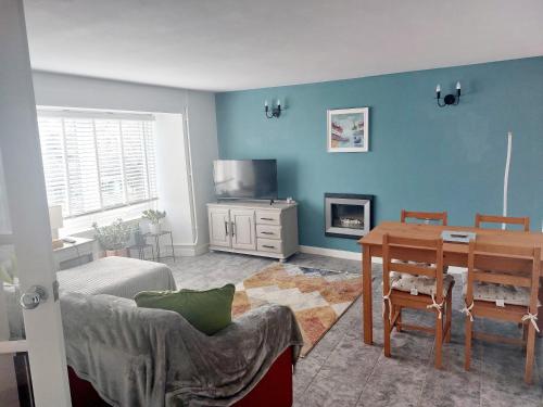 un soggiorno con un tavolo e una sala da pranzo di Cherry Cottage a Goodwick