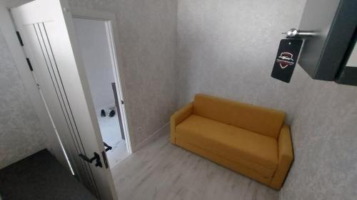 a yellow chair in a room next to a door at Botanica Aeroport in Chişinău