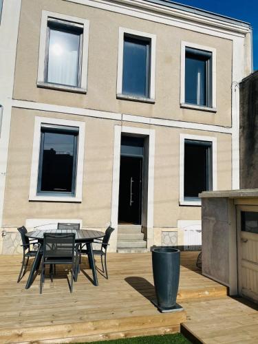 a wooden deck with a table and chairs in front of a building at Casa Volney in Angers