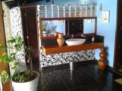 a bathroom with a sink and a mirror at Itaparica - Praia de Ponta de Areia in Itaparica Town