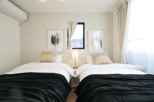 two beds sitting next to each other in a bedroom at Skytree Neighbors close to Asakusa & Tokyo Skytree in Tokyo