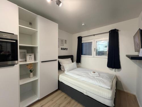 een kleine slaapkamer met een bed en een raam bij Holiday & Stay, Tiny living in Fronreute