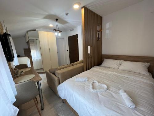 a bedroom with a bed with a heart pillow on it at Amprtman PETKOVIĆ NLux 110 Milmari resort in Kopaonik