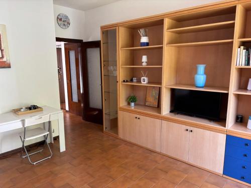 ein Wohnzimmer mit einem TV und einem Schreibtisch in der Unterkunft Novate Fiera in Novate Milanese