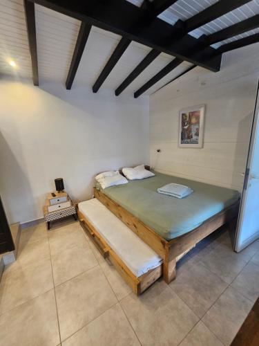 ein Schlafzimmer mit einem großen Bett in einem Zimmer in der Unterkunft Maison 80 m2 super vue montagne piscine 2 chambres in Goyave