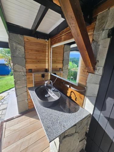 ein Badezimmer mit Waschbecken und großem Fenster in der Unterkunft Maison 80 m2 super vue montagne piscine 2 chambres in Goyave