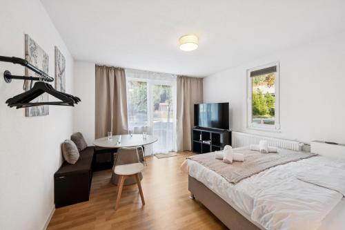 a bedroom with a bed and a table and a sink at KRelax - Bad Wildbad - Moderne Wohnung für 6 Pers in Bad Wildbad