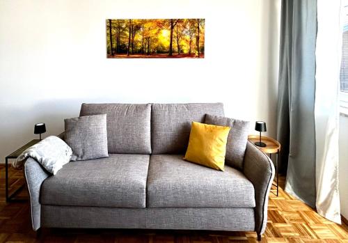 a gray couch with yellow pillows in a living room at Wallersee Retreat in Neumarkt am Wallersee