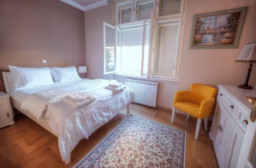 ein Schlafzimmer mit einem Bett, einem Stuhl und einem Fenster in der Unterkunft Crown Apartment - Your Royal Stay in Belgrad