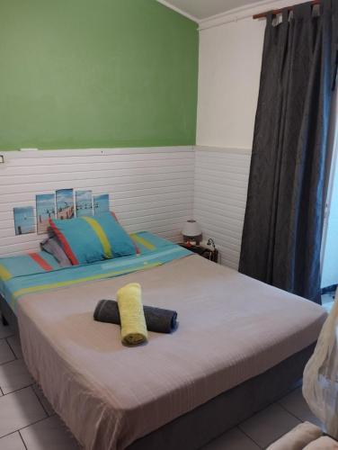 a bedroom with a bed with two towels on it at Petite Kaz KRÉOL in Basse-Terre