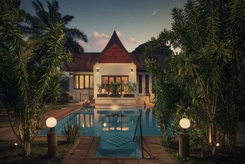 a house with a swimming pool in front of it at Baan Chang Sanctuary in Laguna Phuket