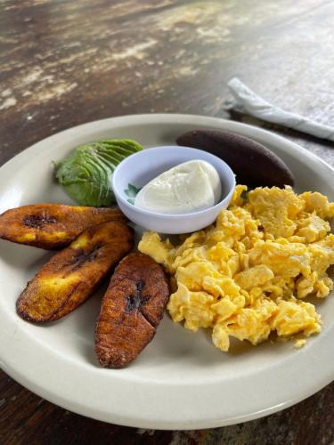 une assiette d'œufs et de pommes de terre et un bol de beurre dans l'établissement Gran Bonanza Hotel, à Alegría