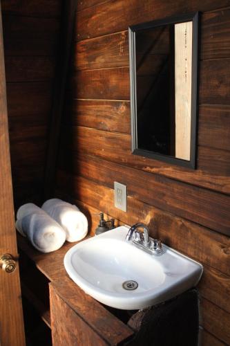 a bathroom with a sink and a mirror and towels at Cabañas Hacienda de Letras in San Luis de Letras