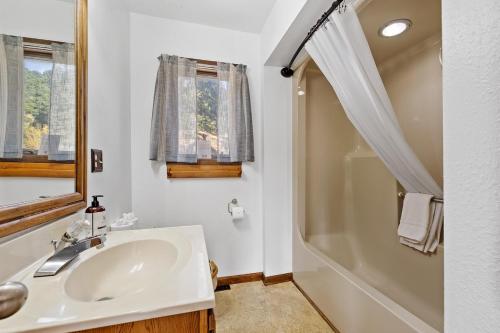 a white bathroom with a sink and a shower at Lead Haven Lodge in Lead